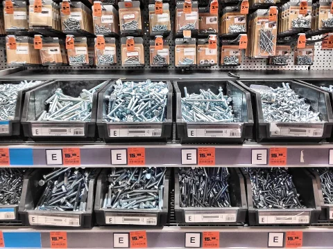 Hardware store shelving with bins of bolts and screws